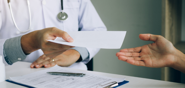 Picture showing a doctor handing their patient a medical form.